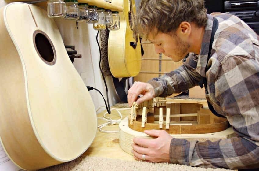 ragazzo artigiano della musica costruisce chitarra